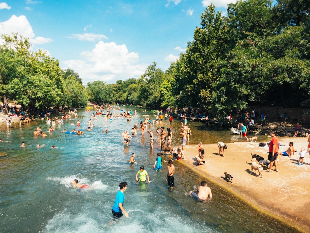 An image of Zilker Park, a dog park Austin residents visit during summer months to swim and enjoy the nice weather.
